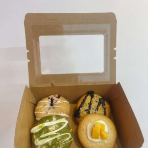 Hộp kraft vuông với 4 chiếc cookie: matcha, framboise, dừa, xoài, logo Mimi Bakes, nền pastel