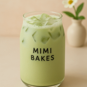 Ly sữa matcha với đá viên trong suốt và logo Mimi Bakes trên nền pastel dịu nhẹ