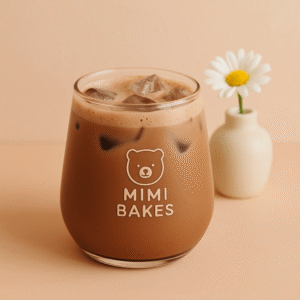 Ly sữa cacao với đá viên và lớp bọt nhẹ, logo Mimi Bakes, đặt trên nền màu pastel cam