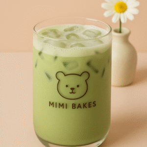 Ly matcha latte với đá viên và lớp bọt nhẹ, logo Mimi Bakes, nền pastel cam