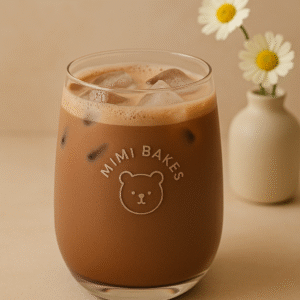 Ly cacao latte với đá và bọt nhẹ, logo Mimi Bakes, nền pastel nâu kem