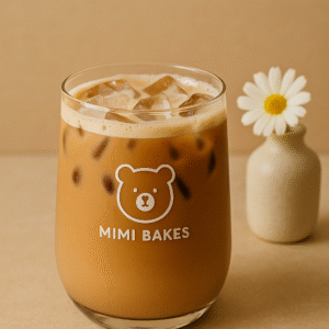 Ly cà phê sữa với đá viên, logo Mimi Bakes, nền màu nâu kem dịu nhẹ