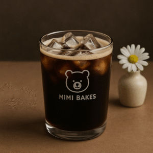 Ly cà phê đen đá với đá viên trong ly thủy tinh, logo Mimi Bakes, nền màu nâu đậm