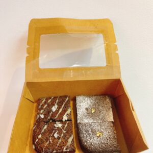 Hộp kraft chữ nhật nhỏ chứa 2 brownie socola đen và 2 brownie phủ dừa, đặt trên nền pastel kem, logo Mimi Bakes